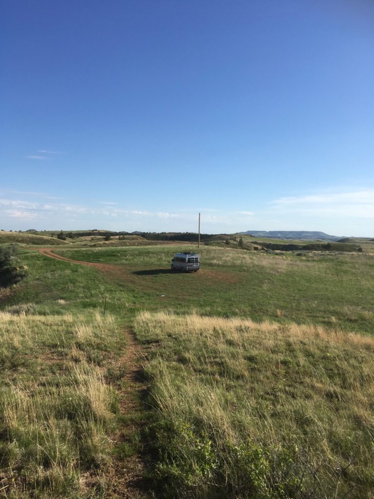 tiny van surrounded by grasslands