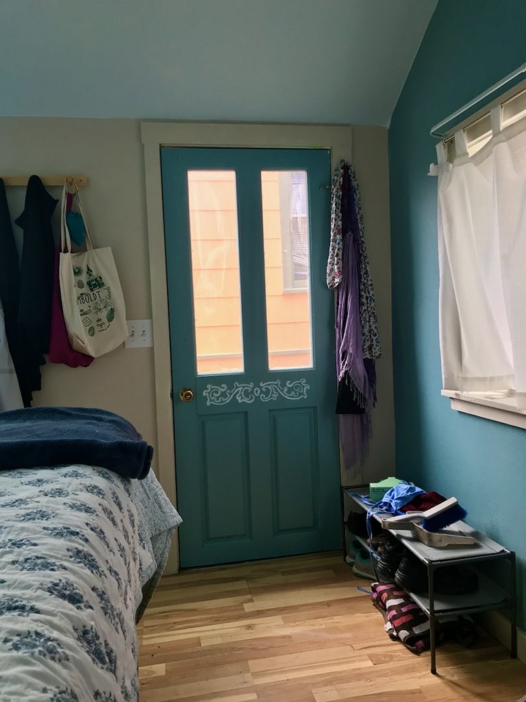 a door with a shoe rack on one side and a coat rack on the other