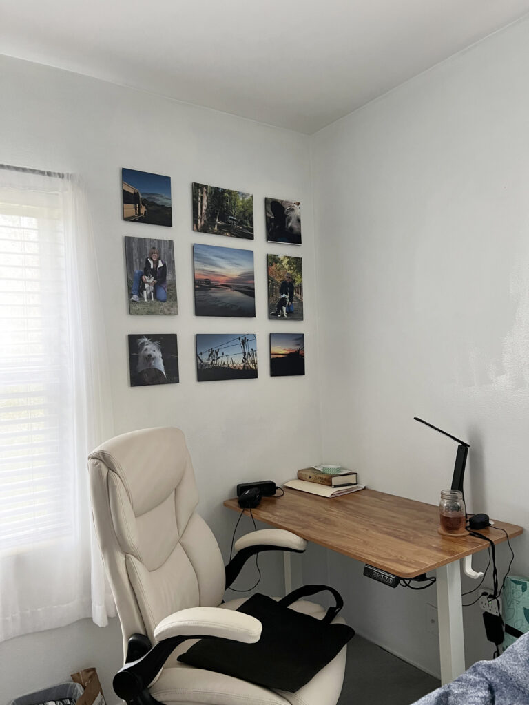photos on a wall over a desk